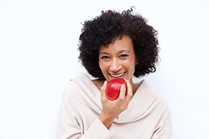 woman biting into a red apple 