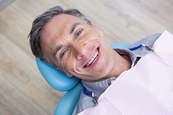 Man smiling while laid back in dental chair and looking up