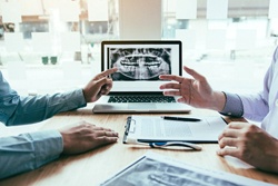 A pair of dentists discussing dental implant treatment.