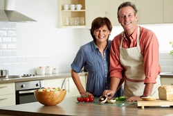 An older couple preparing a meal together.