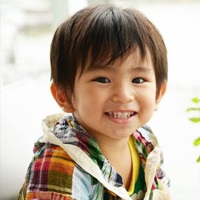 Boy smiling by a fern