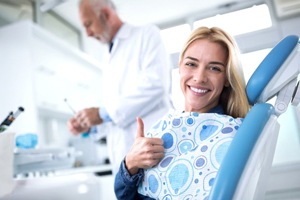 woman giving thumbs up in dental chair