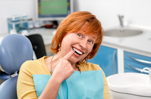 Senior woman pointing to beautiful smile