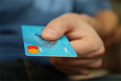 Man’s hand extending credit card