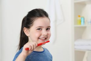 a young girl brushing her teeth