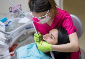 dentist cleaning patient's teeth