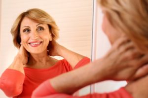 Senior woman in front of mirror admiring her smile