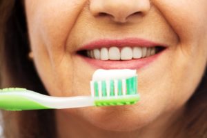 person brushing their dental implants in San Antonio