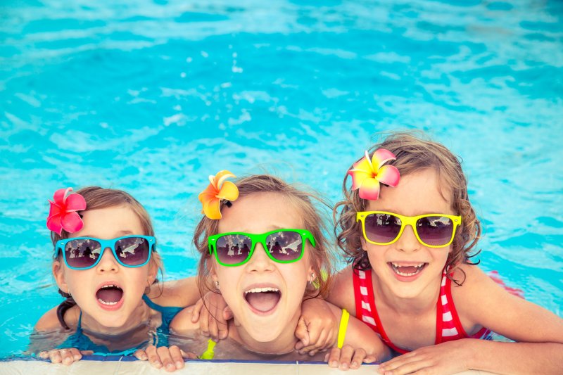 three kids in the pool during the summer