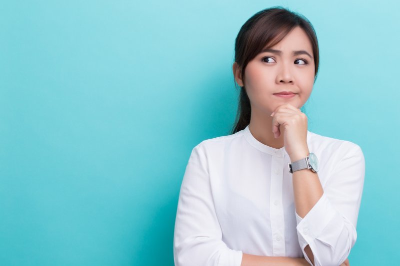 Closeup of woman in white shirt thinking