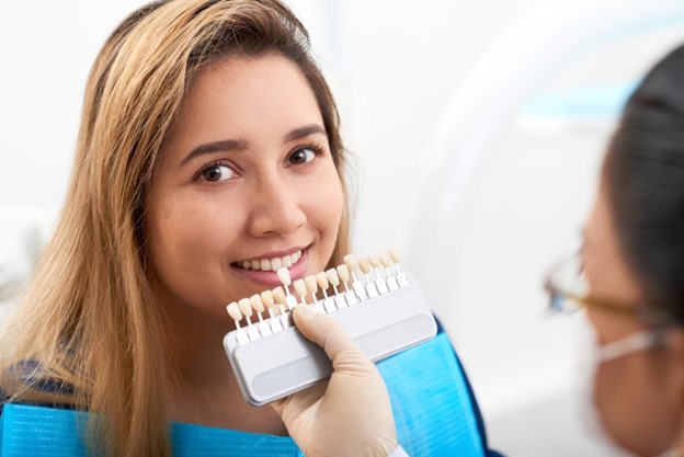 Woman receiving porcelain veneers from her dentist.